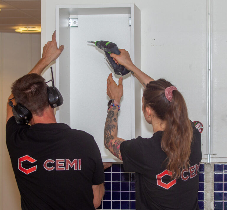 Våra snickare sätter upp en hylla under en badrumsrenovering.